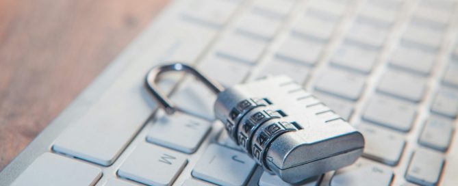 A combination lock rests on a computer keyboard.