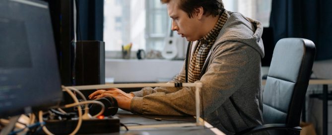 Free A concentrated professional working at a computer in a modern office setting. Stock Photo