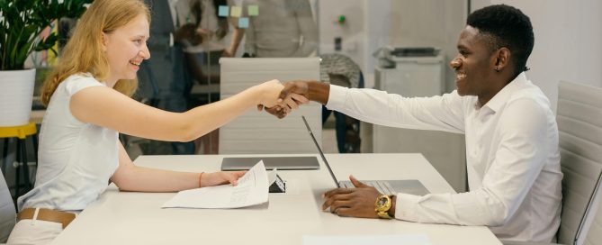 Free Business professionals completing a successful deal with a handshake in a modern office setting. Stock Photo